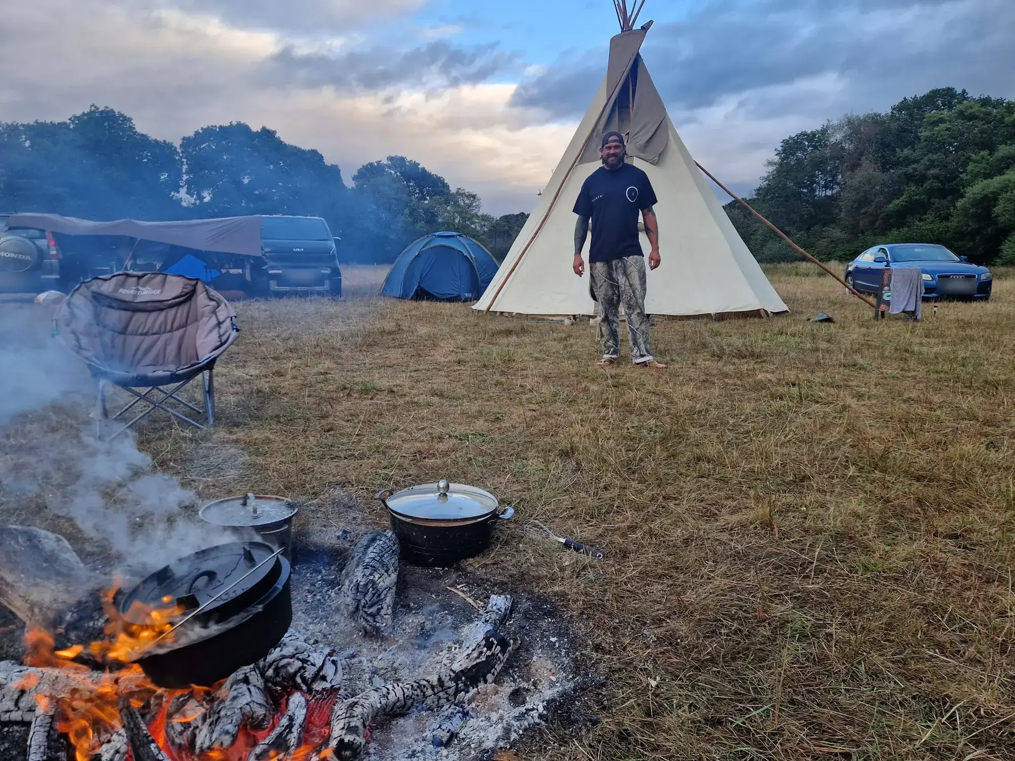 Cast iron pots on the fire in front of the tipi