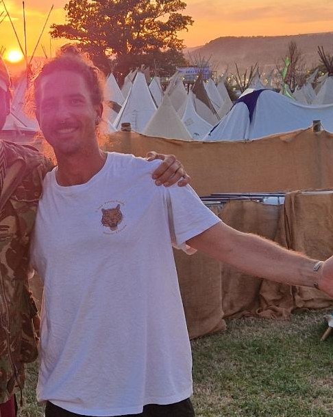 Reni at sunset in the Tipi Field, arm out, smiling
